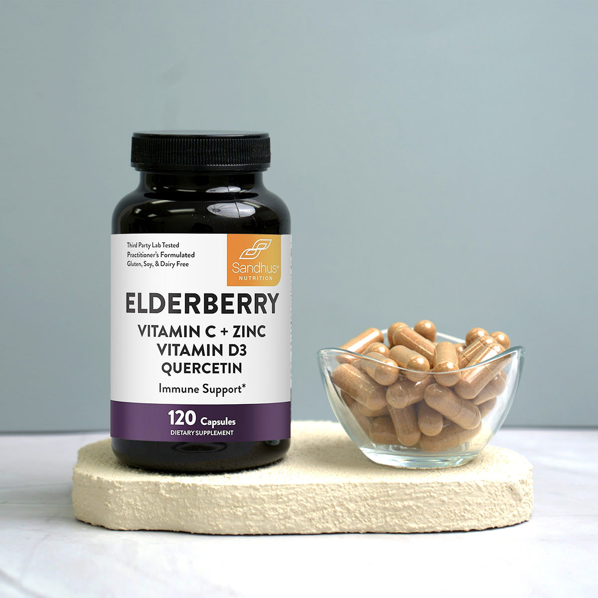 Supplement bottle labeled 'Elderberry Vitamin C + Zinc Vitamin D3 Quercetin' with capsules on a light surface.