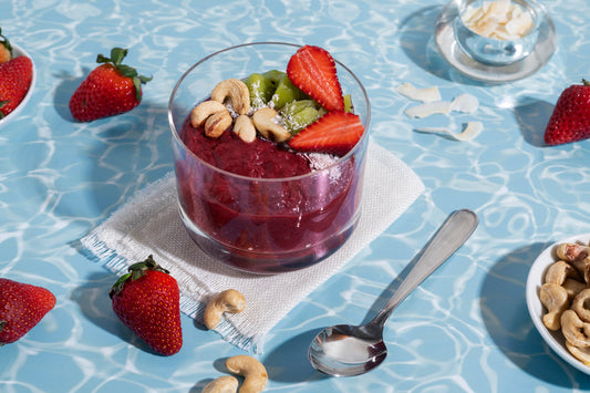 Healthy berry smoothie bowl topped with strawberries, kiwi, cashews, and coconut flakes for a refreshing immune-boosting recipe.