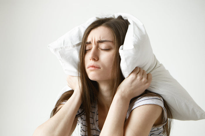 Person struggling to sleep comfortably during winter nights due to disrupted sleep patterns