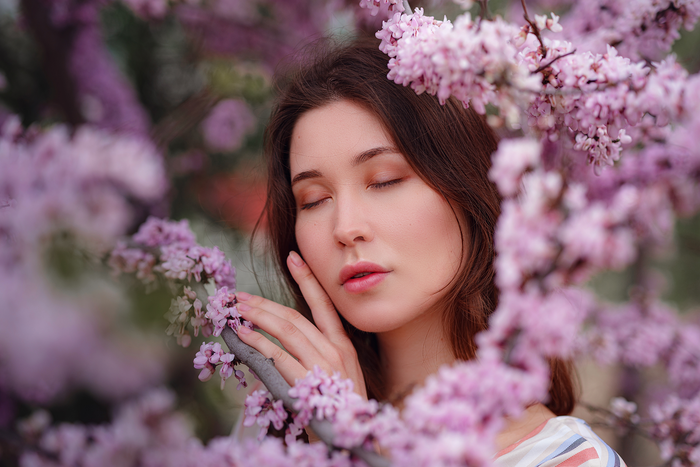 Woman relaxing among blooming spring flowers representing calmness, recovery, and natural relief from spring fatigue