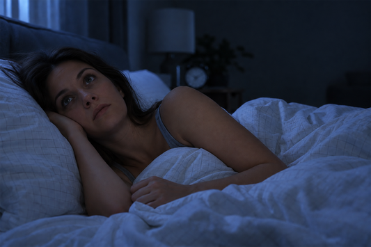Woman lying awake in bed at night, illustrating difficulty winding down, nighttime alertness, and the second wind that can occur before sleep.