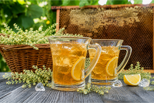 Refreshing iced mullein tea with lemon slices served in glass mugs alongside fresh mullein herbs, offering a cooling herbal beverage for warm weather.