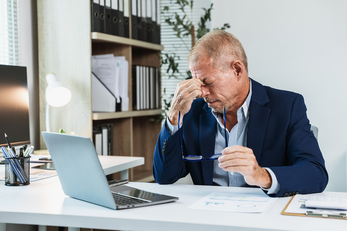 Stressed office professional experiencing mental fatigue, brain fog, and reduced focus caused by workplace stress and burnout