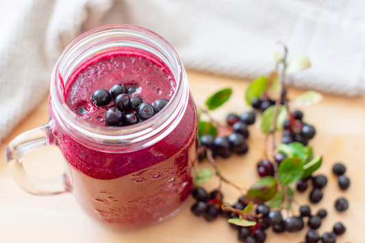 Fresh elderberry smoothie topped with berries, showcasing a refreshing and flavorful addition to summer wellness routines