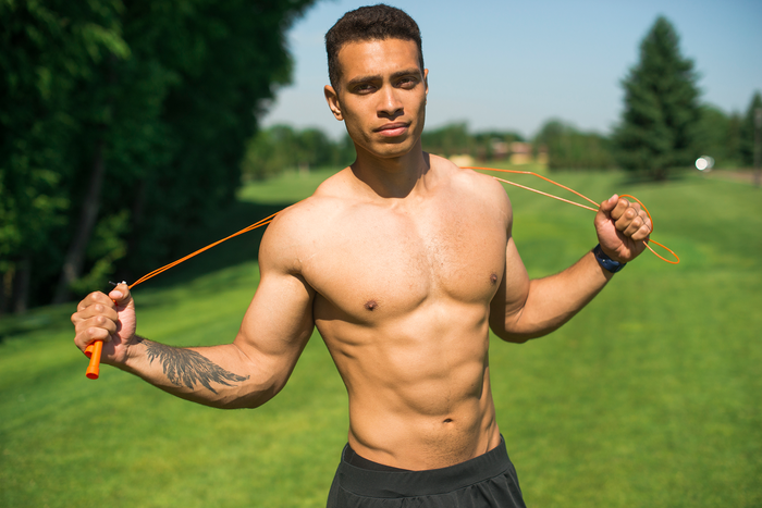 Fit man holding jump rope outdoors representing stamina muscle endurance and the role of vitamin D3 in energy support