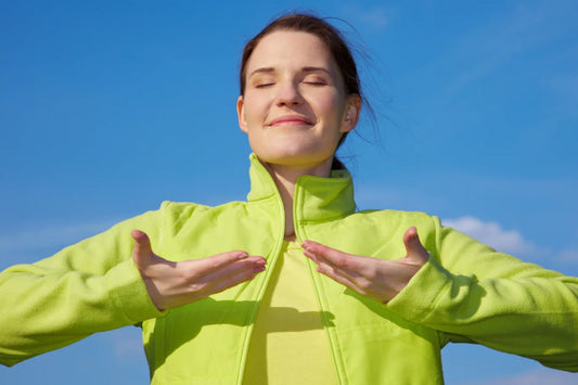 Woman practicing deep breathing outdoors illustrating natural lung cleansing and mindful breathing for respiratory wellness
