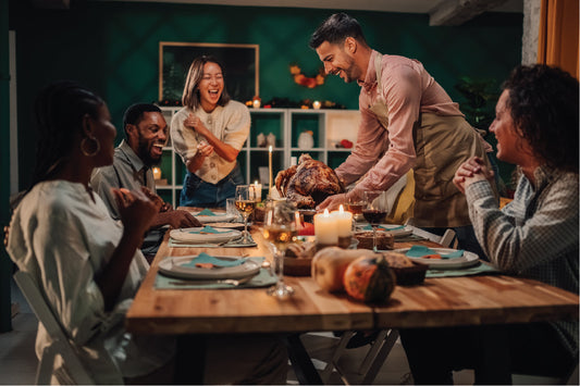 Thanksgiving dinner celebration with friends and roasted turkey on the table.