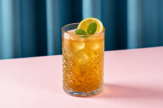 Glass of iced mullein tea with lemon slices, fresh mint, and ice cubes, showcasing a light, refreshing herbal drink for summer.