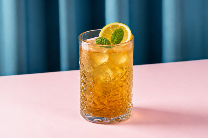 Glass of iced mullein tea with lemon slices, fresh mint, and ice cubes, showcasing a light, refreshing herbal drink for summer.