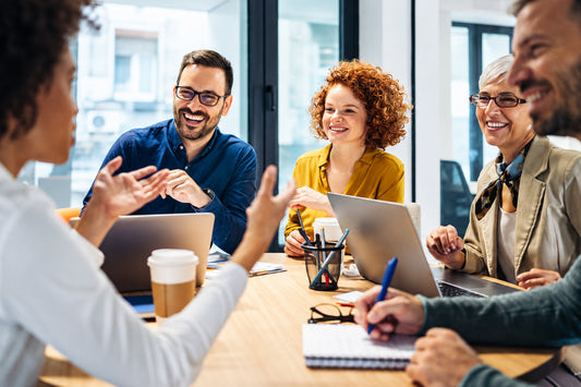 A diverse team collaborating in a busy office meeting, discussing ideas and sharing insights to improve workplace focus, productivity, and mental performance.