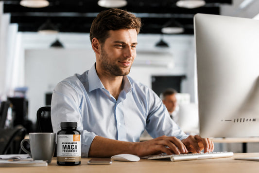 Professional working at a desktop with an Ashwagandha and Maca supplement nearby, promoting natural energy, focus, and afternoon productivity.
