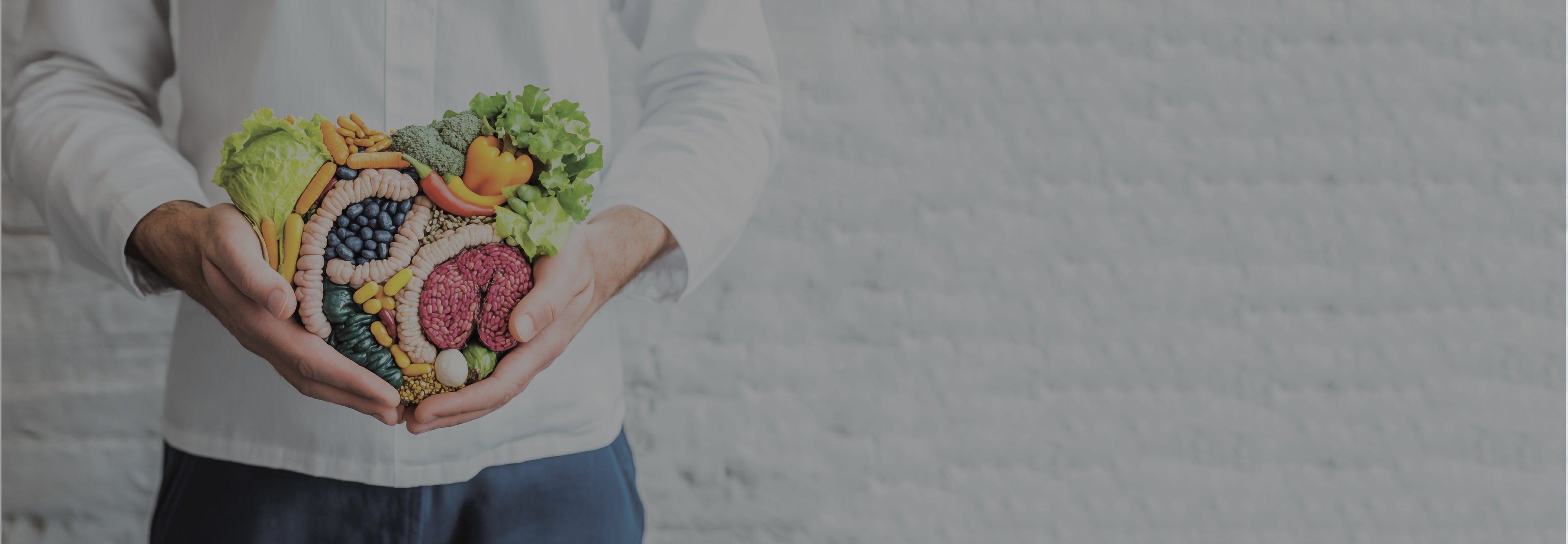 Holding a heart-shaped arrangement of fruits and vegetables with a blurred background