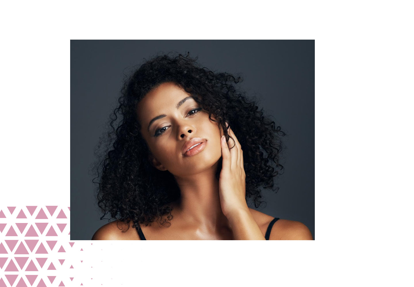 Woman with curly hair against a dark background